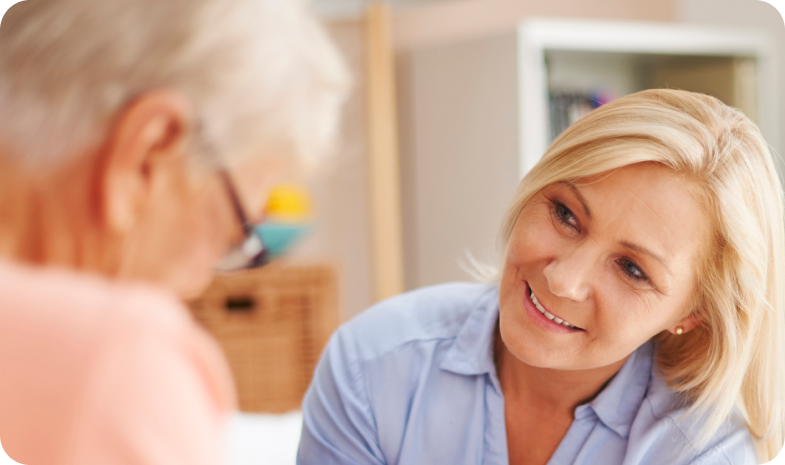 A middle-aged woman is having a conversation with an older woman about what to expect during a Beltone hearing test.
