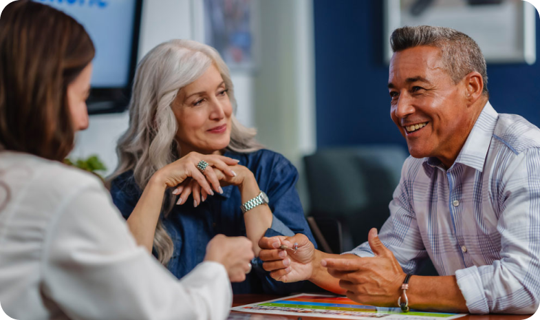 A middle-aged couple speak with a Beltone audiology specialist.