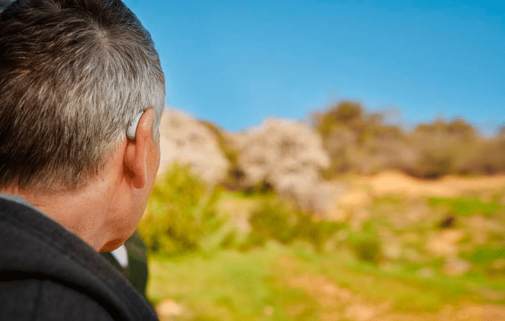 Man wearing light colored hearing aids