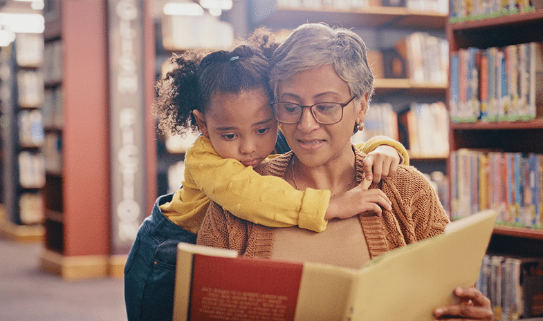 child reading book with adult